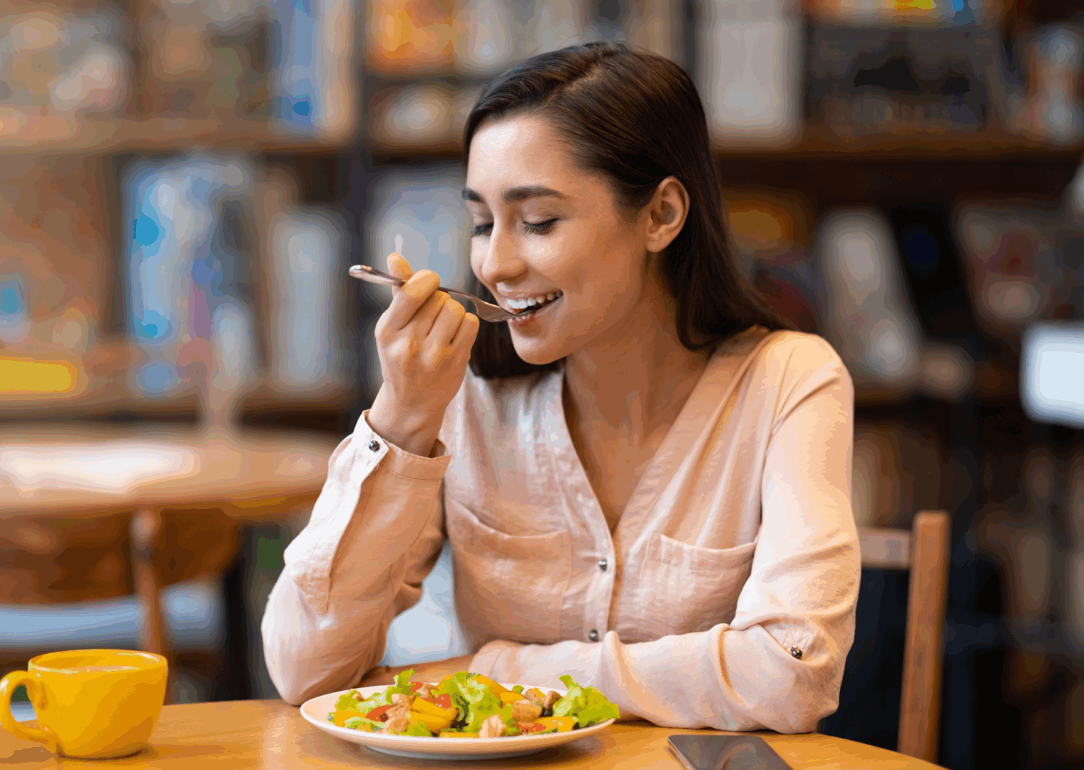 Woman enjoying a salad in a cafe.