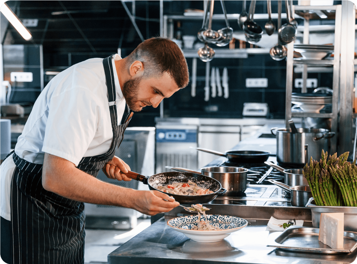Chef plating food in a professional kitchen.